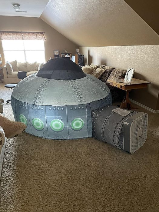 A reviewer’s air fort designed to look like a spaceship, connected to a floor fan