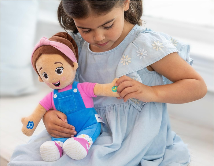 A child holding the Ms. Rachel plush doll