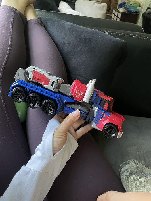 A reviewer holding the Optimus Prime toy in truck mode