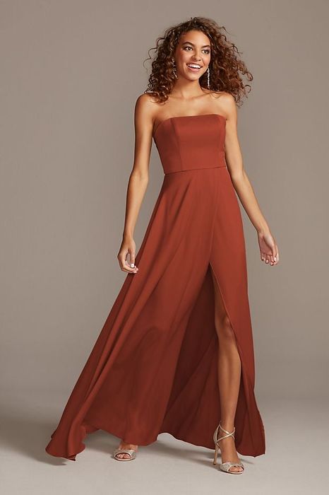A model showcasing the strapless gown in a warm cinnamon hue.