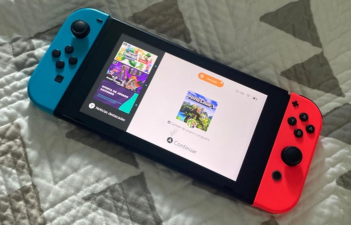 A reviewer’s handheld Nintendo Switch console with detachable red and blue Joy-Con controllers