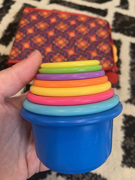 A tower of rainbow-colored toy cups stacked together