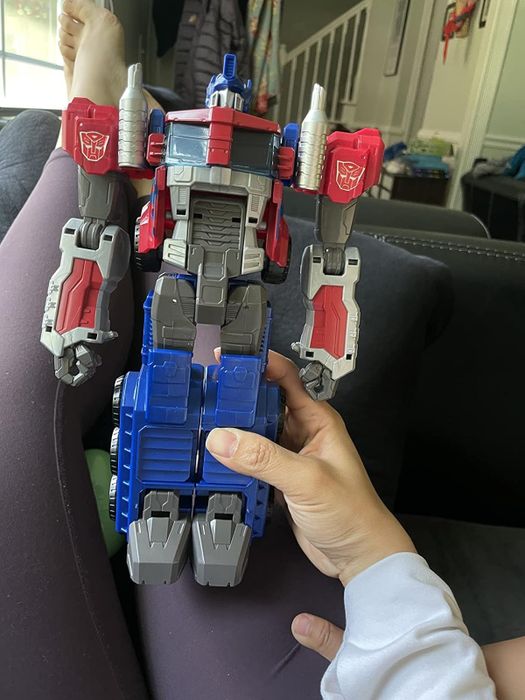 A reviewer holding the Optimus Prime toy