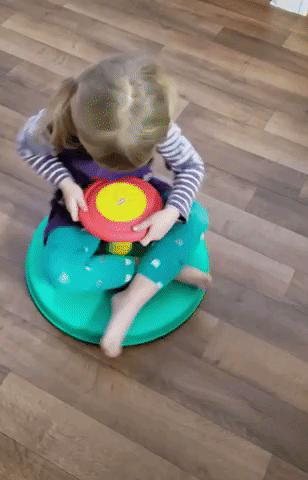 A reviewer's child spinning happily on the toy