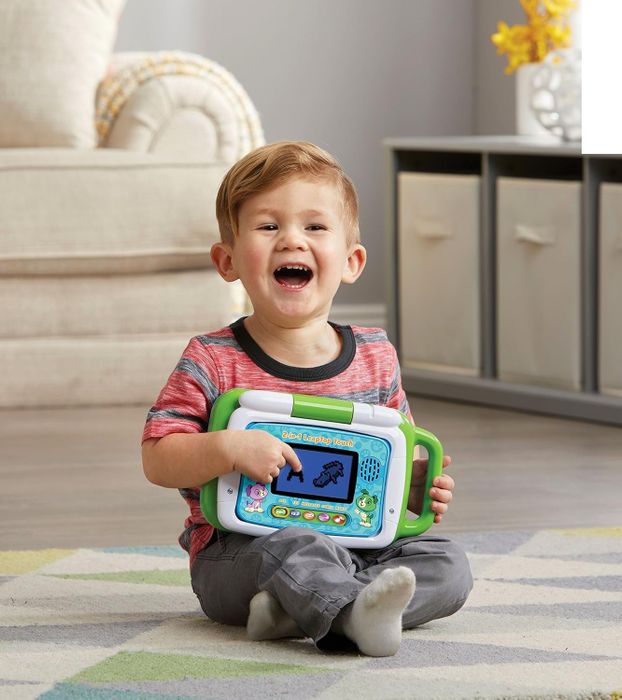 A child pointing to the toy tablet