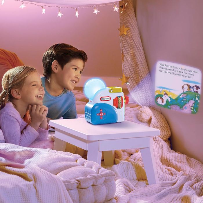 Two children enjoying a bedtime story with a toy projector