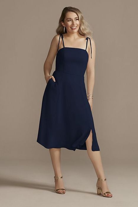 A model striking a pose in the classic navy blue dress