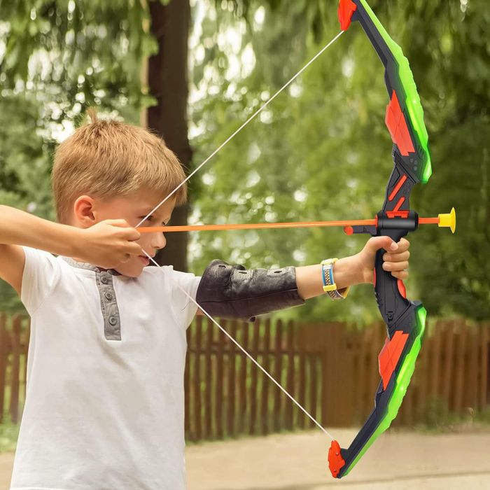 A child demonstrating how to shoot with a green bow and arrow