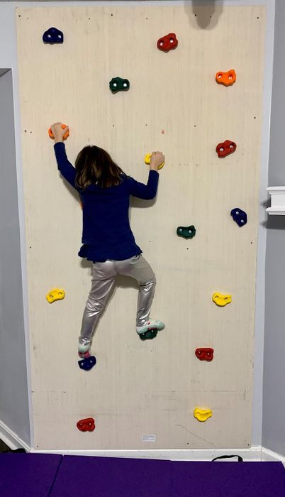 Image of a reviewer’s child climbing the rock wall set