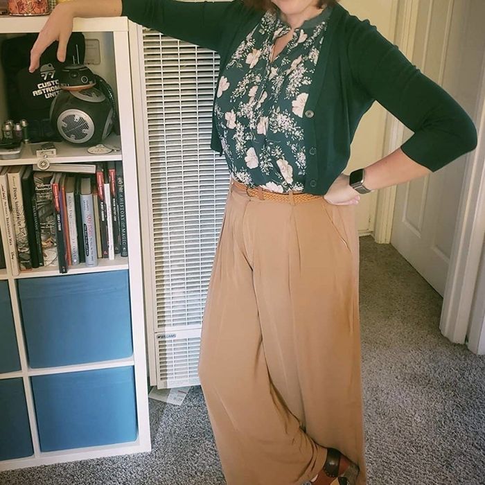 A customer wearing tan flowing palazzo pants with a blouse and cardigan