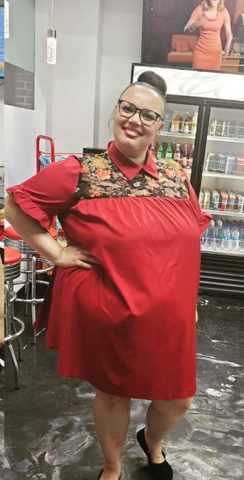 A reviewer wearing the dress in a bold red shade.