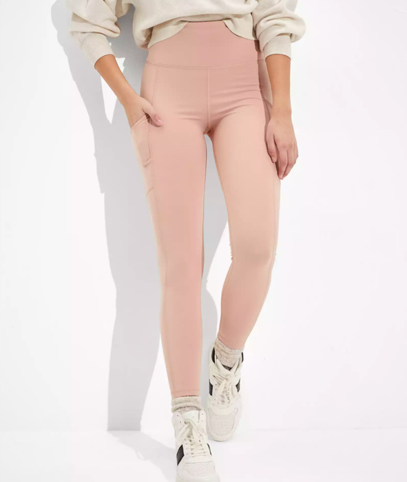 A model is wearing light pink leggings paired with white sneakers.