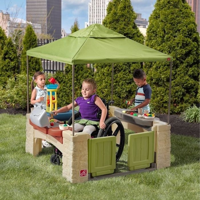 Children enjoying a play set with shade