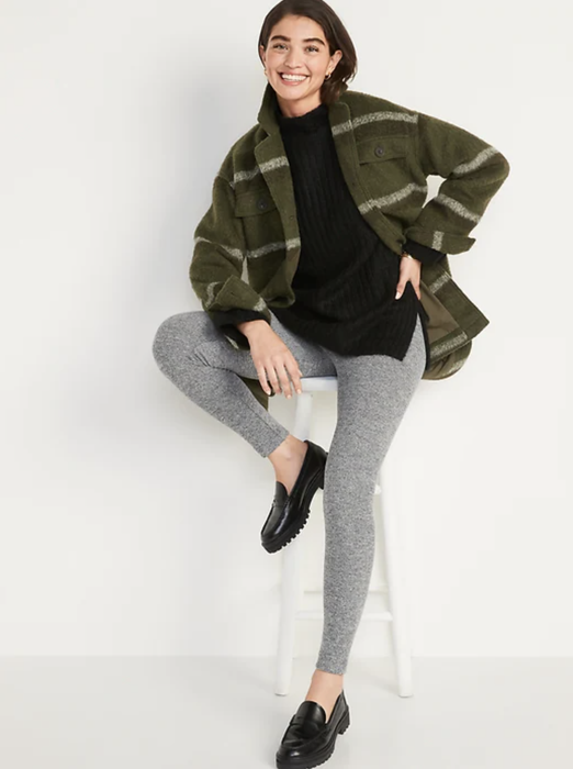 A model showcasing gray heather leggings styled with black loafers and a green gingham flannel