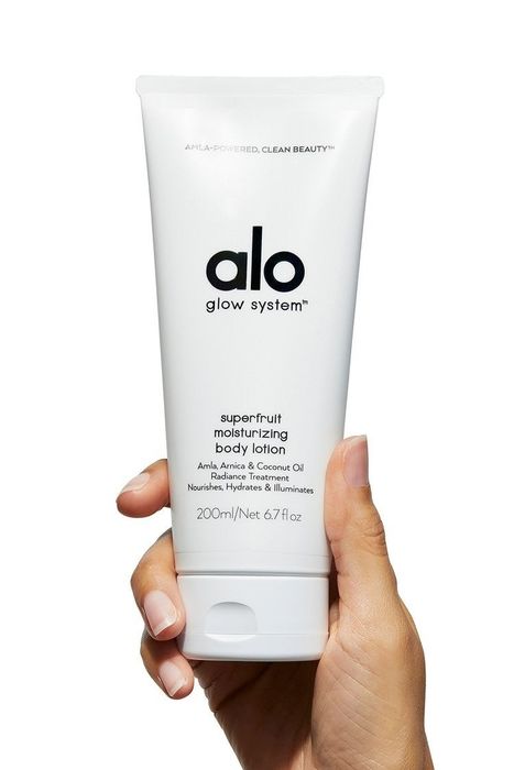 A hand holding a tube of lotion