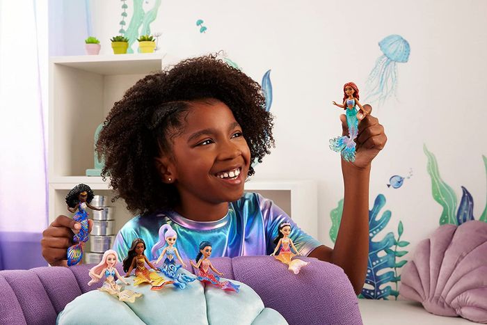 a kid enjoying playtime with mermaid dolls