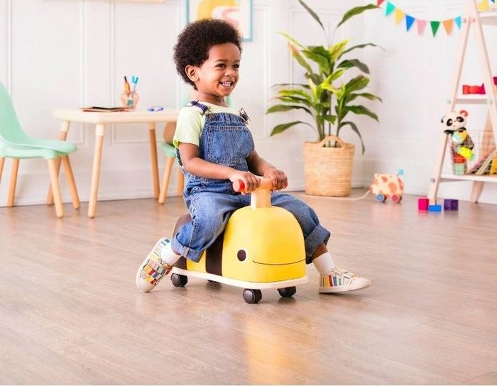 Child riding a bee-shaped push car