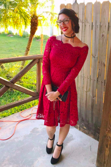 A reviewer wearing a red boatneck fit-and-flare dress with long sleeves.