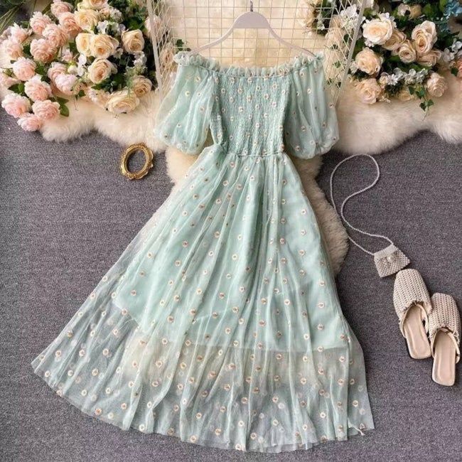 A smocked puff-sleeve tulle dress in soft mint green, featuring delicate embroidered flowers.