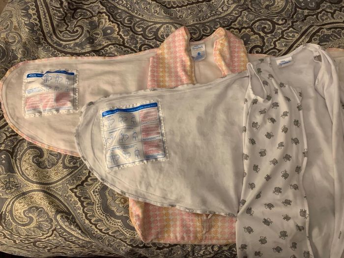 A variety of swaddling clothes are arranged on a patterned surface, displaying different styles and designs, with no people or brand names in view.