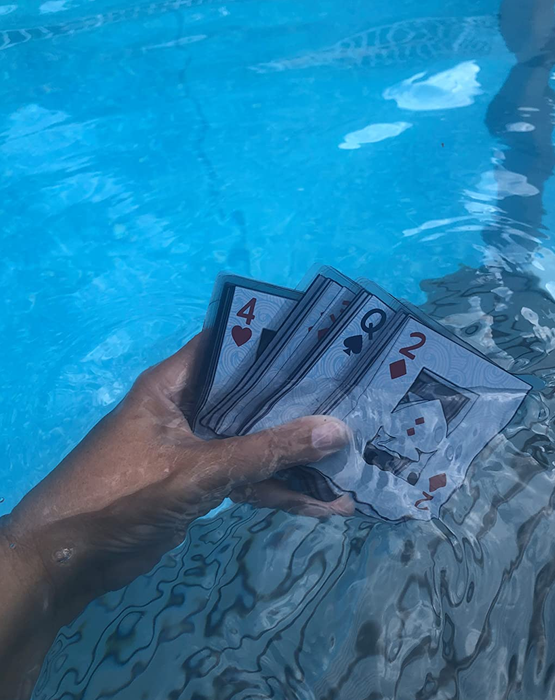 Reviewer holding a deck of waterproof cards in the pool