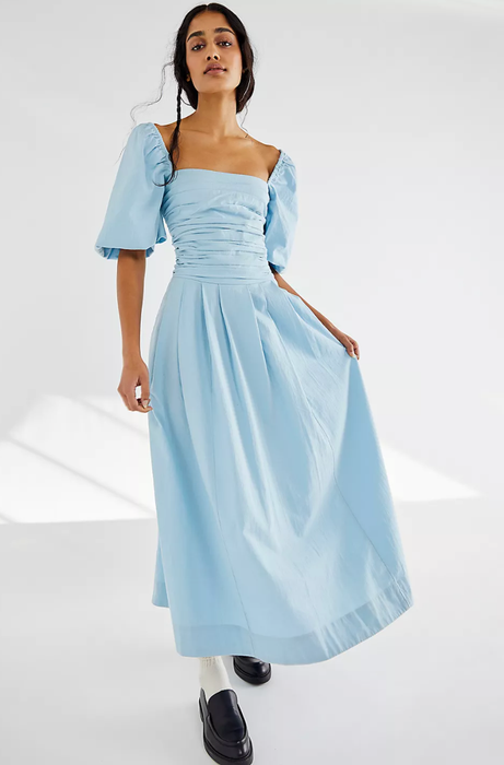 A model in a blue puff-sleeved maxi dress with a square neckline.