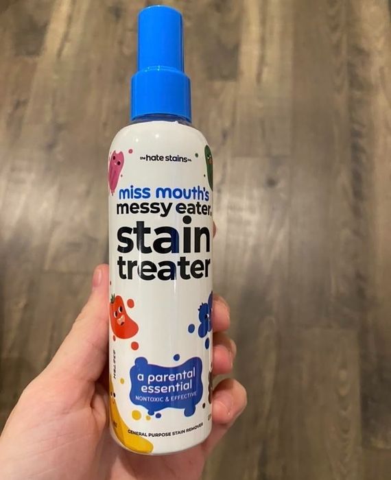 A hand holds a bottle of 