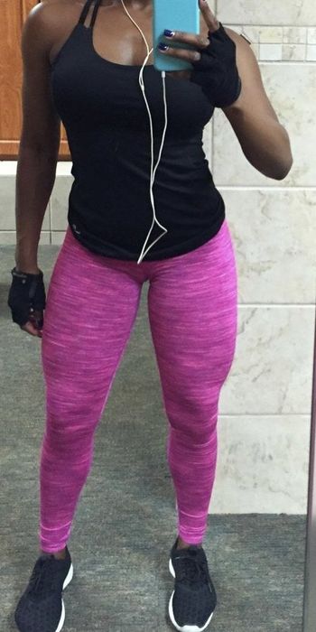 A person poses in bright pink leggings.