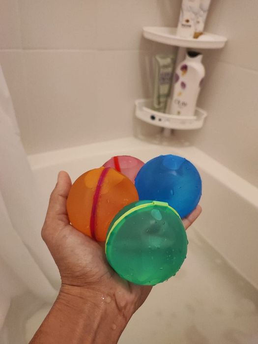 reviewer holding a set of water balloons