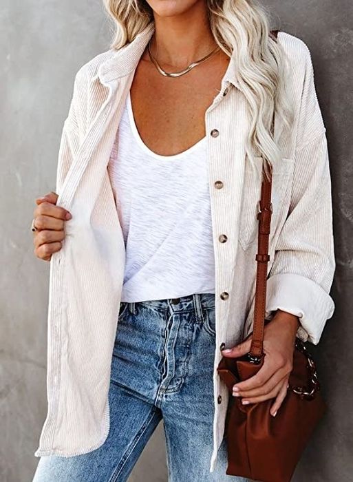 Model styled with a white tank top underneath and paired with jeans