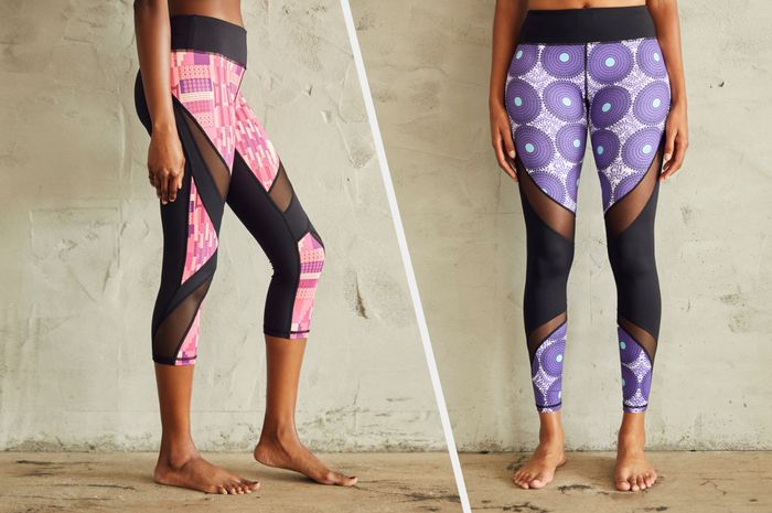 A model displaying a side view of pink zig-zag capri leggings with black mesh, alongside another model wearing purple medallion leggings with black mesh detailing