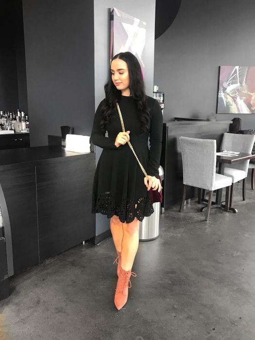 A reviewer showing off the long-sleeved dress in black.