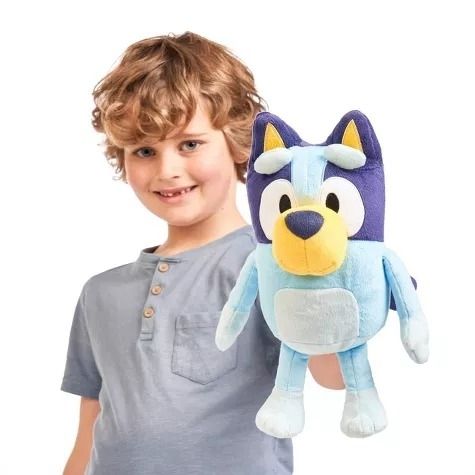 Child holding a Bluey plush toy