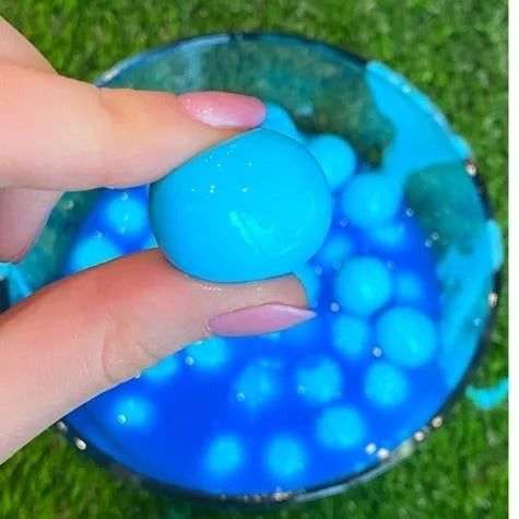 A hand gripping a paintball ready for action