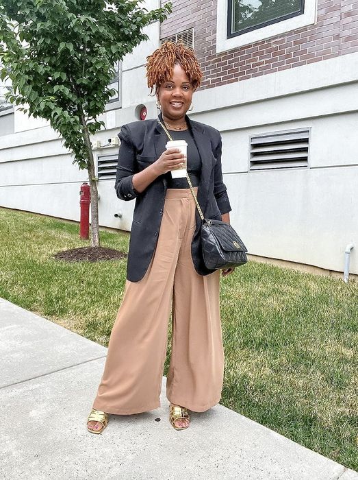 A reviewer showcasing the camel-colored wide-leg pants.