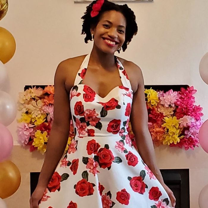 The dress in white featuring a red rose print.