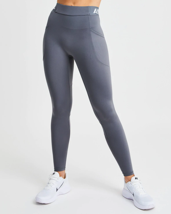 A model is wearing grey leggings paired with white sneakers.