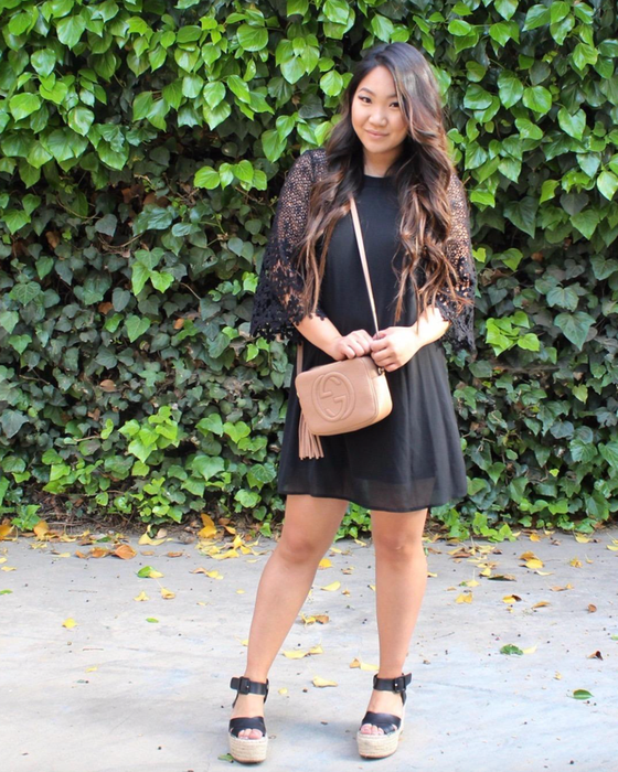 Model in a black lace-sleeve midi dress