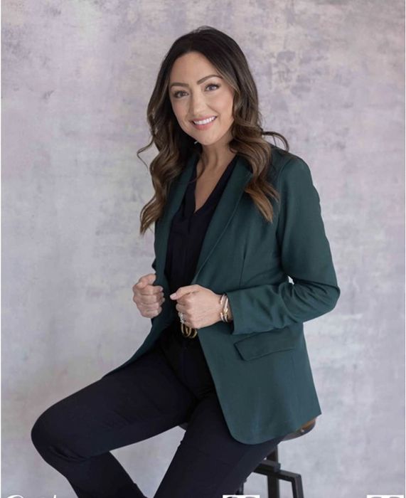 A reviewer styling the blazer in a bold green hue