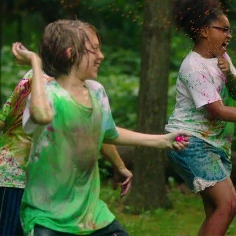 Children playfully throwing paintballs at each other
