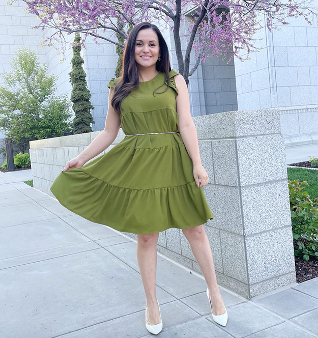 Reviewer in a green tiered midi dress with ruffled sleeves