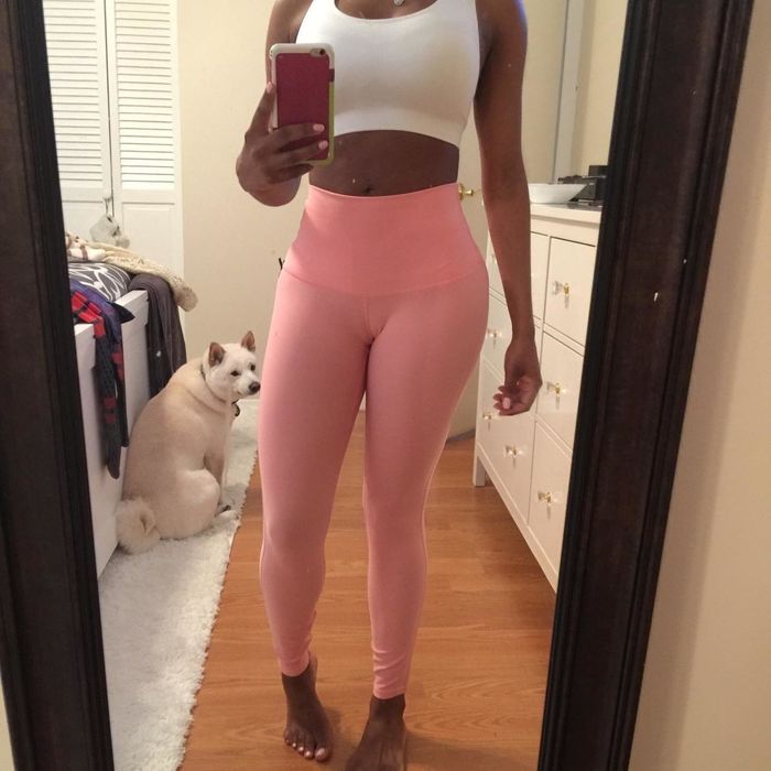 A reviewer is wearing leggings in a vibrant pink color.