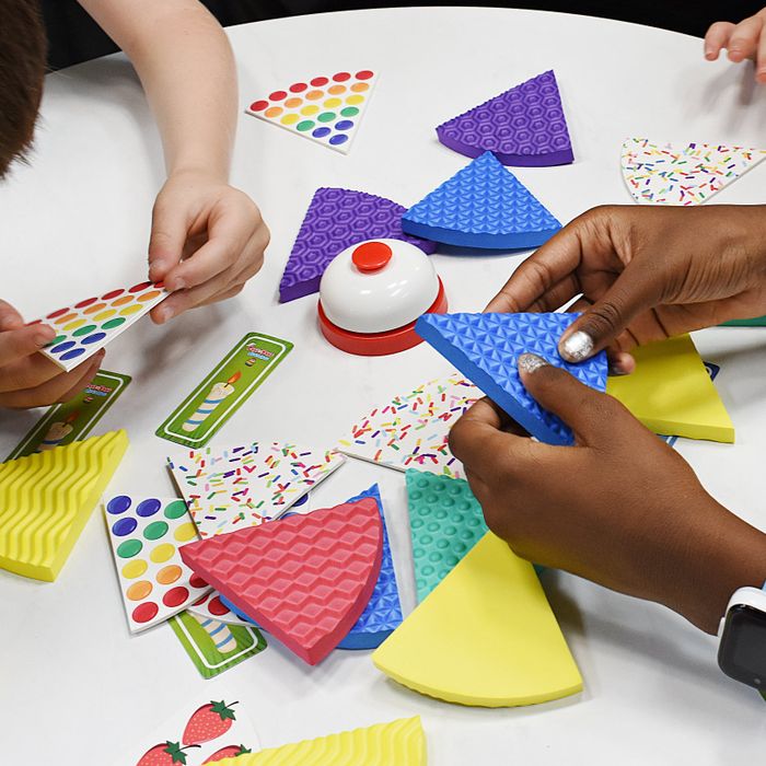 Hands engaged in the cake game on the table
