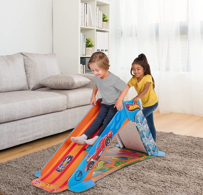 A child sliding down while another climbs up the ladder
