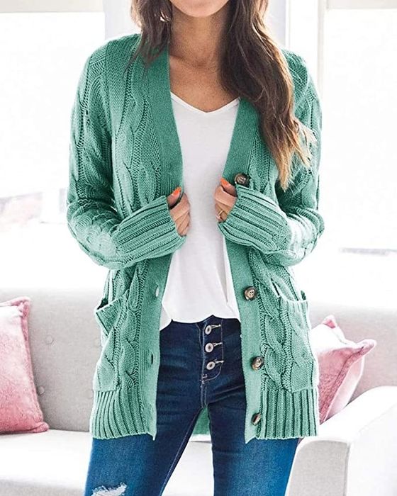 A model wearing the green cardigan open over a white tee.
