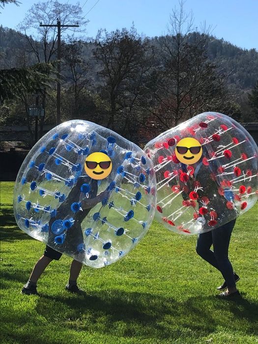 A photo of two teens inside their own bumper balls