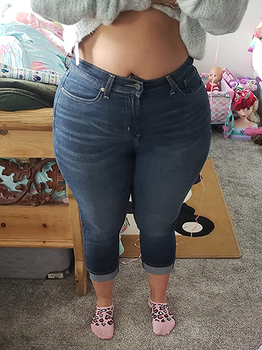 front view of reviewer in cropped jeans paired with a white cropped sweater and pink leopard print socks