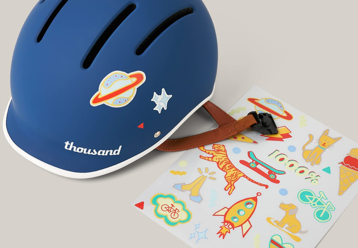 A blue helmet adorned with stickers, along with an extra sticker sheet for customization