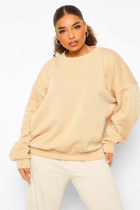 The model is styled in a stone Boohoo fleece loopback sweatshirt.