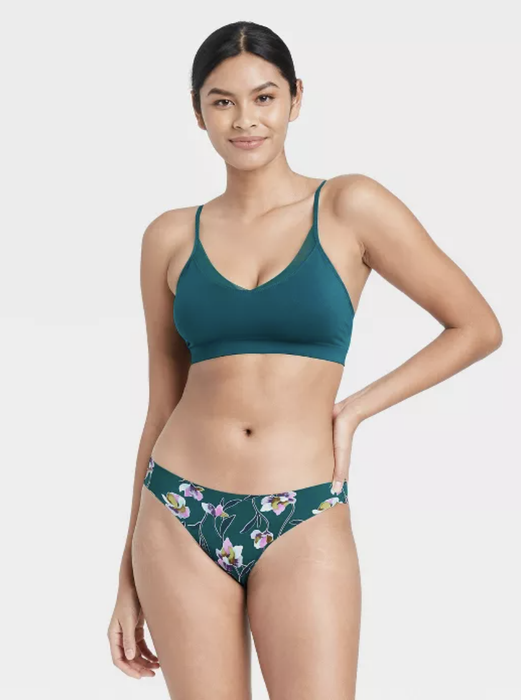 A model wearing no-show underwear in a teal and floral print.